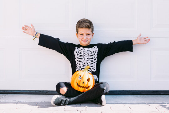 Screaming boy in Halloween outfit with pumpkin