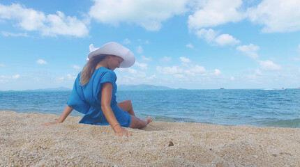 Young beautiful women in the blue on the sunny tropical beach