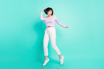 Fototapeta na wymiar Full length photo of shiny sweet woman dressed violet sweater smiling dancing isolated turquoise color background