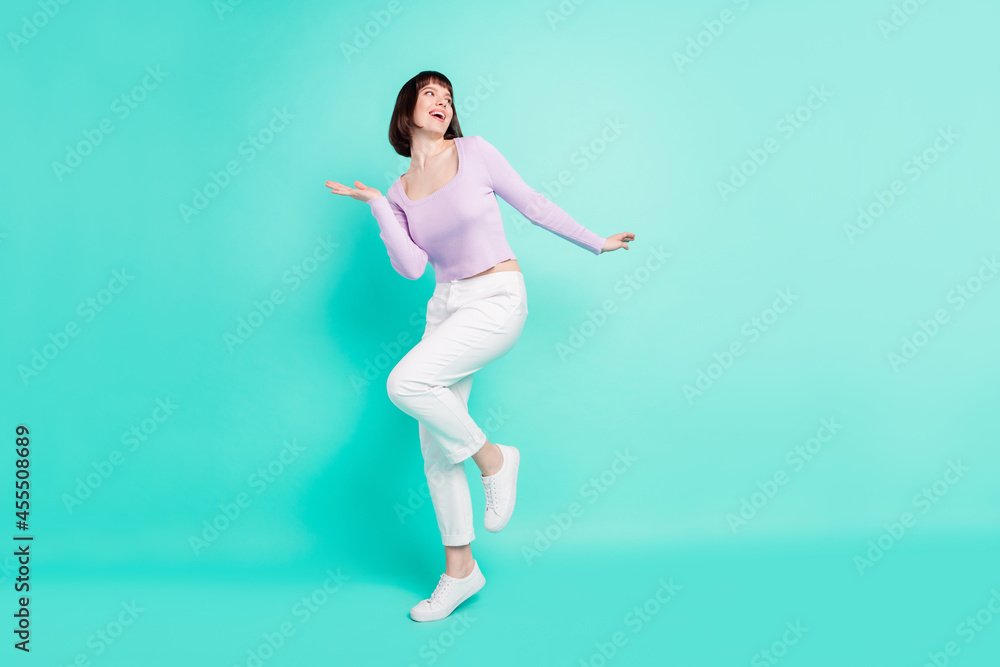 Wall mural Full length body size photo woman happy overjoyed dancing at party looking copyspace isolated vivid teal color background