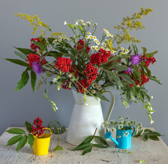 Beautiful bouquet of meadow flowers and branches with red elderberries.