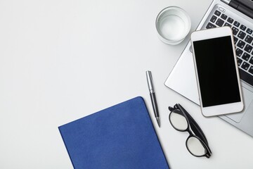 Modern office desk with a smartphone, laptop