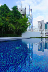 The beautiful swimming pool with a building scenery of Kuala Lumpur and reflection on the pool. 