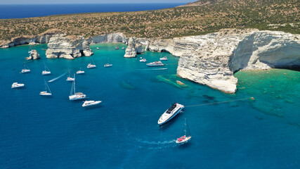 Obraz premium Aerial drone photo of Kleftiko a beautiful scenic white volcanic rock formation bay visited by sail boats and yachts with turquoise crystal clear sea and caves, Sea Meteora of Greece, Milos island