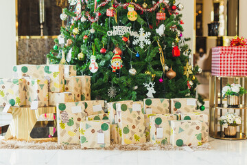 Boxes decorated with Christmas gifts under a Christmas tree at home.