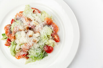 Caesar salad with salted fish on a white plate. Traditional festive snack. Close-up. White background. Space for text.