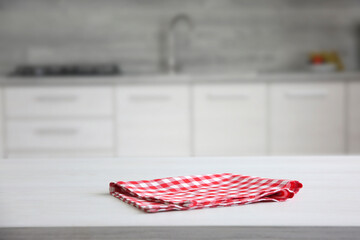 Red checkered folded picnic cloth on table empty advertisement space. Towel top.