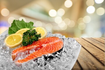 Fresh raw fish Fillets on a plate with lemon and parsley.