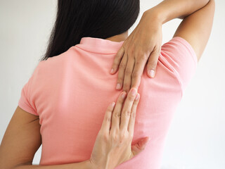Asian woman suffering from shoulder pain on white background. closeup photo, blurred.
