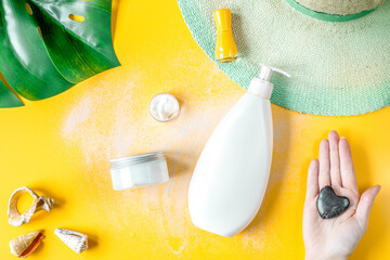 Woman cosmetic set with sun protection lotion orange background top view