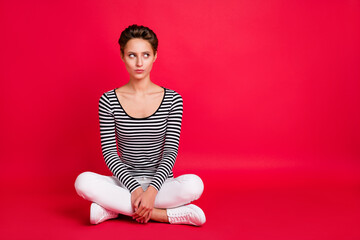 Photo of doubtful serious young lady wear striped clothes sitting legs crossed looking empty space...