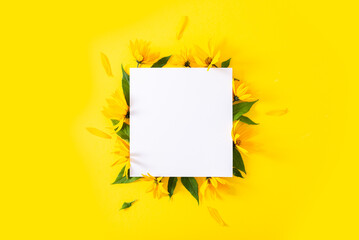 Naklejka premium Empty white paper blank, flowers, branches on yellow background. Wedding branding mock up, holiday marketing concept. Copy space