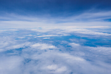 Naklejka premium Aerial view scene of the sea or ocean which hiding under white fluffy clouds and blue bright sky background.