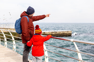 Father and son standing at the sea in winter