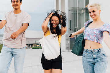 Group young muliethnic people friends walking outdoor on windy day smiling having fun