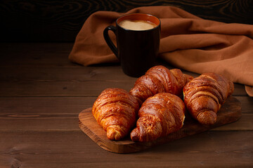 Pastries,Croissants on a brown wooden table, with a cup of coffee, breakfast, no people, rustic style,