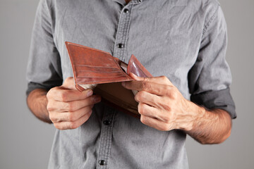 man shows an empty leather wallet.