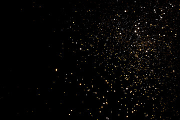Golden and silver blurred bokeh lights on black background. Glitter sparkle stars for celebrate