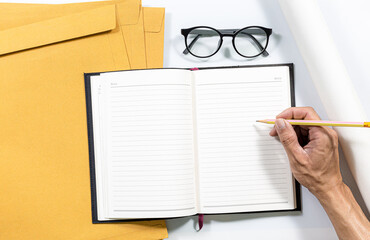Notebooks, notebooks and envelopes on a white desk,Notebook with glasses and document holder, lays...