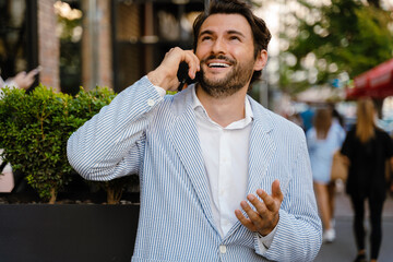 Young man talking on mobile phone while standing outdoors