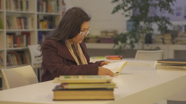 Elderly lady binge reading her fav novels at Argentinian library