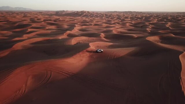 Aerial view of 4x4 off road vehicle taking tourists on desert dune bashing safari in Dubai, UAE. Drone footage View Of Sports Cars Dune Bashing. Desert safari Dubai.
