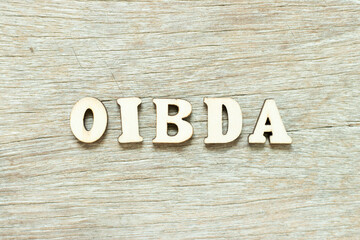 Alphabet letter in word OIBDA (Abbreviation of .Operating Income Before Depreciation and Amortization) on wood background