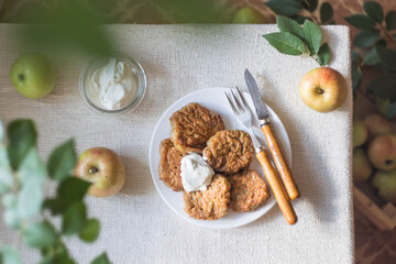 Apple fritters for breakfast. Delicious and hearty pancakes with sour cream and fresh apples. Top view