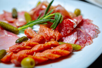 Spicy and smoked sausage snacks served on white plate in meat restaurant