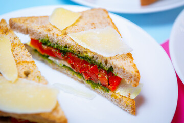 Club sandwich with red fish fillet and parmesan cheese with pesto sauce served for lunch in cafe