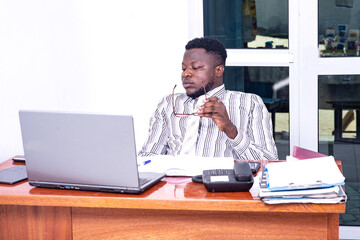 young businessman holding his optical glasses in the office.