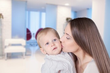 Young beautiful mother lifting and playing with her baby.