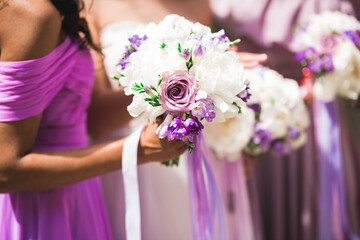 Bride with bridesmaids holding wonderful luxury wedding bouquet of different flowers on the wedding...