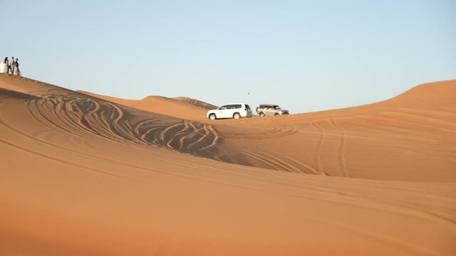 4x4 off road vehicle taking tourists on desert dune bashing safari in Dubai, UAE. View Of Sports Cars Dune Bashing. Desert safari Dubai.