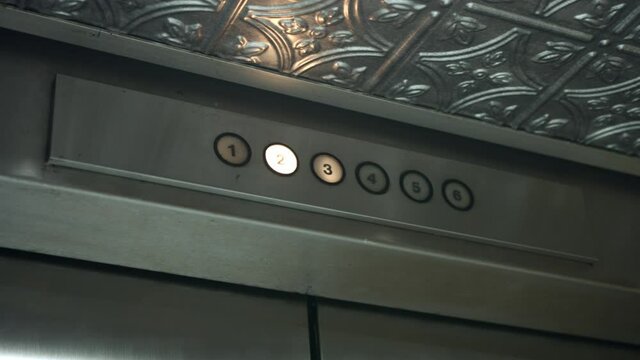 Floor Designators With Braille Characters Flashing Light Above Door Jamb Of An Elevator In A Parking Building. low angle