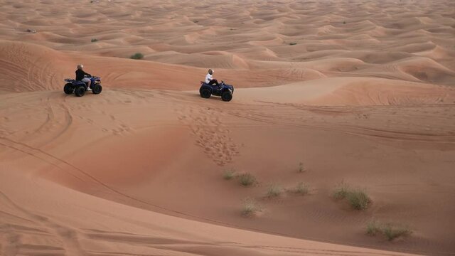 Four Wheeler - Quad Biking off road vehicle taking tourists on desert dune bashing safari in Dubai, UAE. View Of Sports Cars Dune Bashing. Desert safari Dubai.