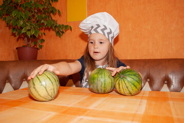 Fototapeta premium harvest day, cook's day, a girl in a cook's cap with arbks on the table canns blanks for the winter