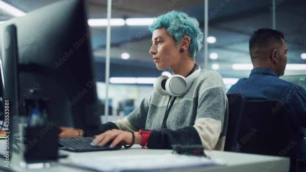 Poster in diverse multi-ethnic office: portrait of young stylish woman working on desktop computer. non-bin