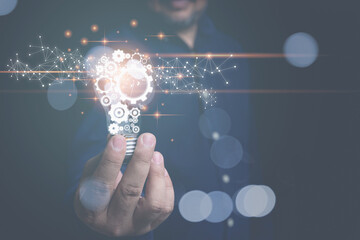 Inspiration from online digital technology. Business, Development, Creative idea, Innovation concept. Businessman holding a light bulb, and a gear icon in it with copy space.