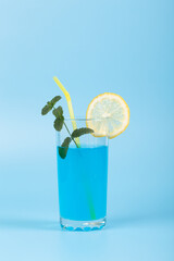 Glass with refreshing blue drink and fruits