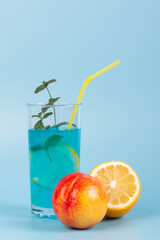 Glass with refreshing blue drink and fruits