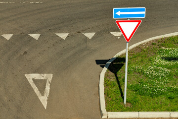 Motorway junction with sign give way on a summer day.