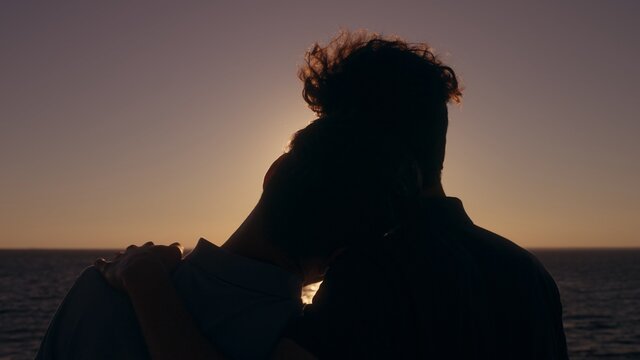 Gay couple hugging at sunset, boyfriend hugging partner, love relationship