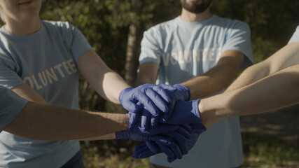 Close-up of volunteers stacking hands, active people ready to help, motivation