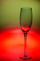 Taça de cristal em fundo colorido em degrade com as cores verde e vermelho.