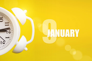 January 9th. Day 9 of month, Calendar date. White alarm clock on yellow background with calendar...