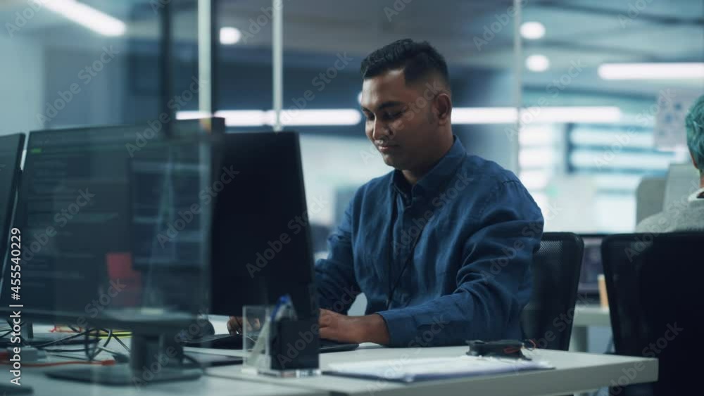 Poster in diverse office: portrait of handsome indian man working on desktop computer. focused professional