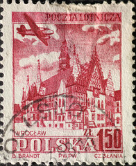 POLAND-CIRCA 1954: A post stamp printed in Poland showing a historic town hall building with a propeller plane in the sky