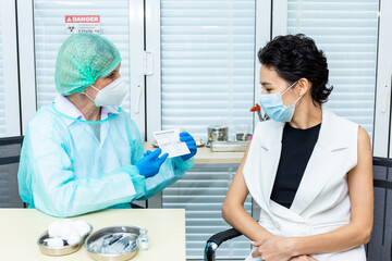 Female doctor wearing mask performs vaccination Write vaccination record card Covid-19 hospital approval. Female doctor vaccinating middle-aged patients from a virus. Concept coronavirus. Vaccination