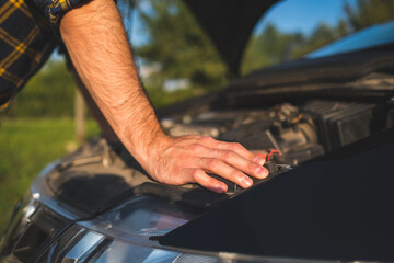 man checking his car engine